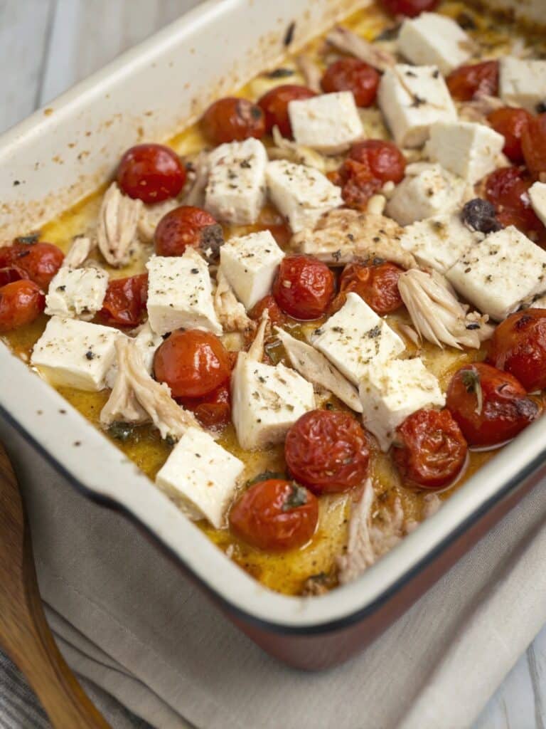 Baked feta and chicken with tomatoes in a dish