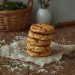 Stack of high-protein pizza breakfast biscuits with herbs and cheese