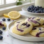 Blueberry cheesecake swirl cookies with cream cheese and fresh blueberries on white plate